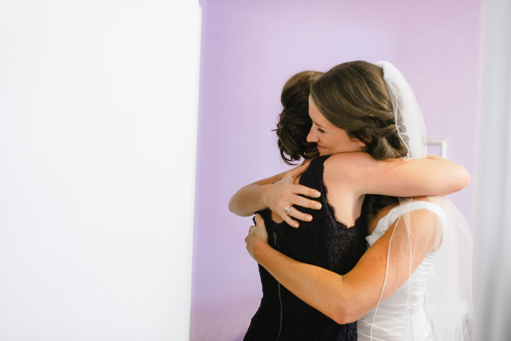 Mom and bride hugging